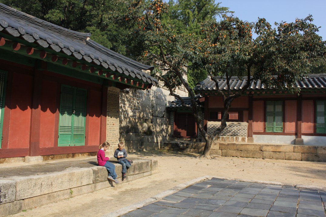 Tuva och Vilmer har fått nog av gamla tempel och hittar istället på en lek med ekollon. Seoul, Sydkorea, 2012.